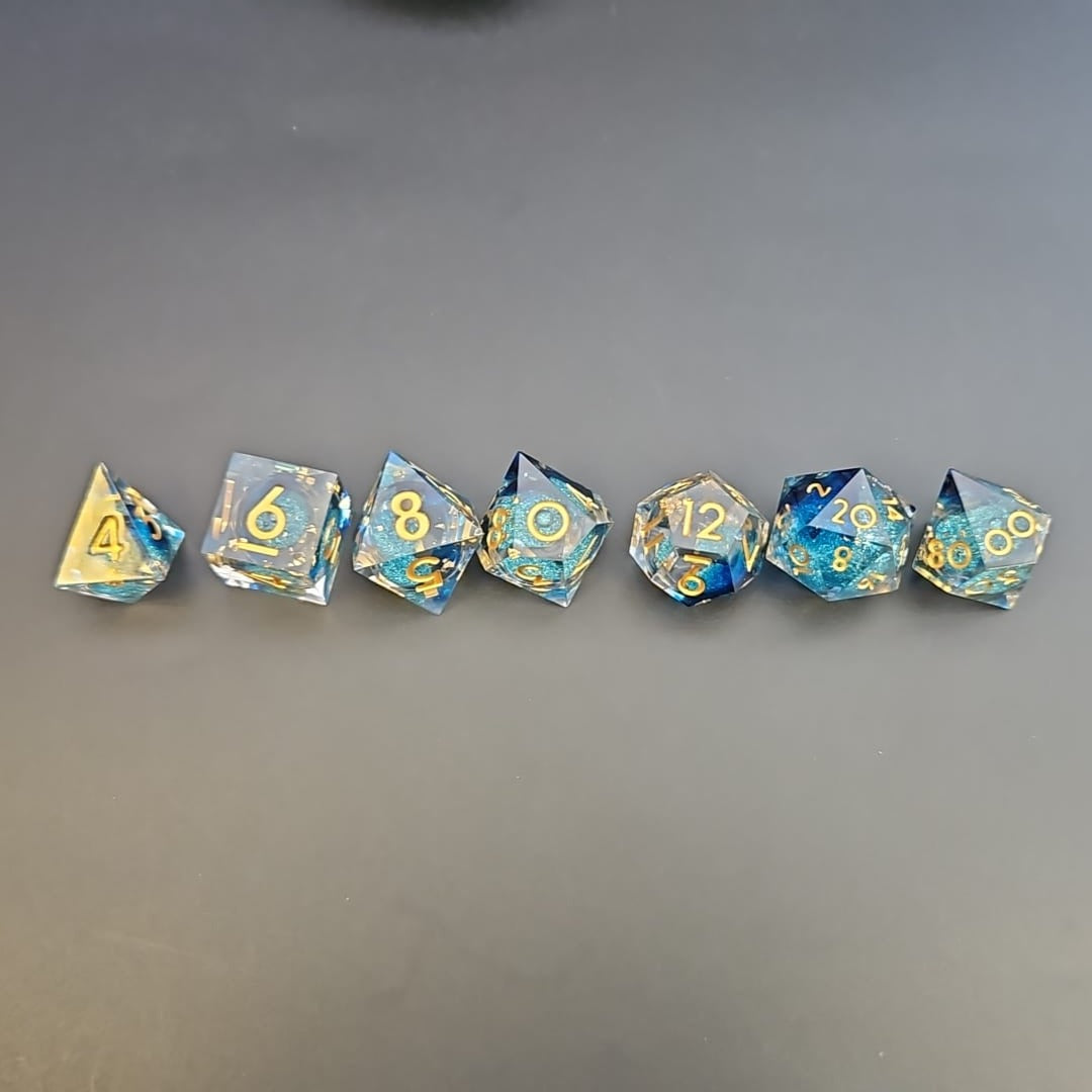 Clear & Blue Glitter 7 Piece Liquid Core Dice Set with Gold Numbering and highlights, in Metal Box
