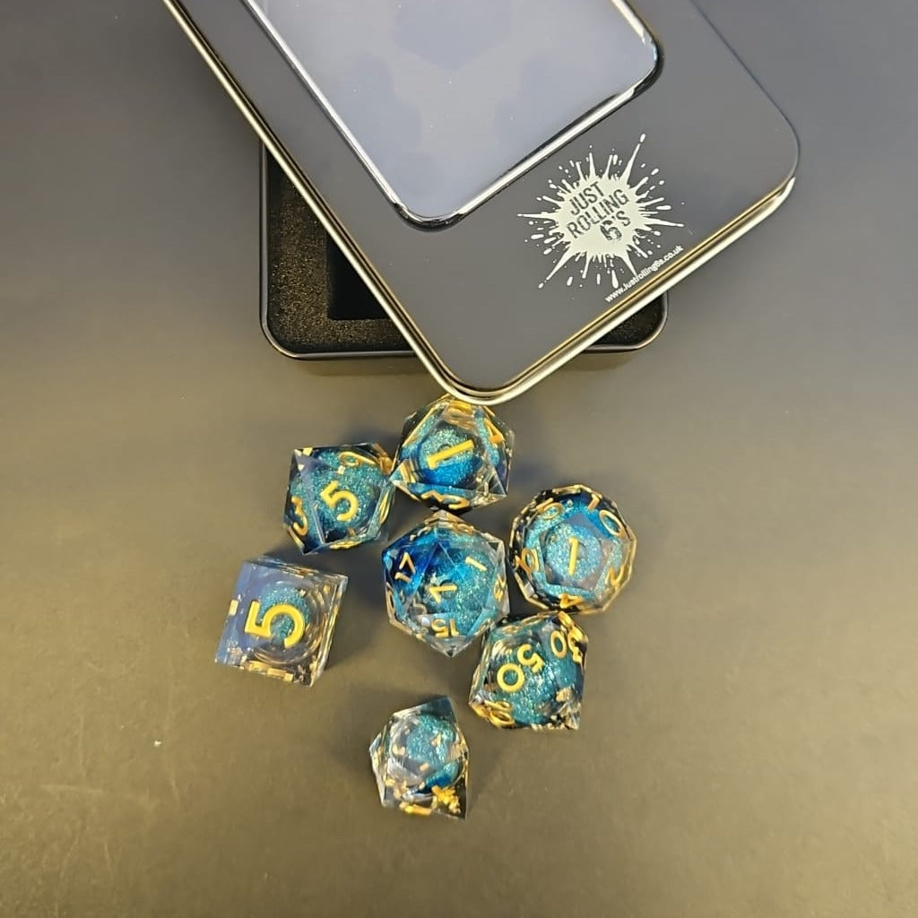 Clear & Blue Glitter 7 Piece Liquid Core Dice Set with Gold Numbering and highlights, in Metal Box
