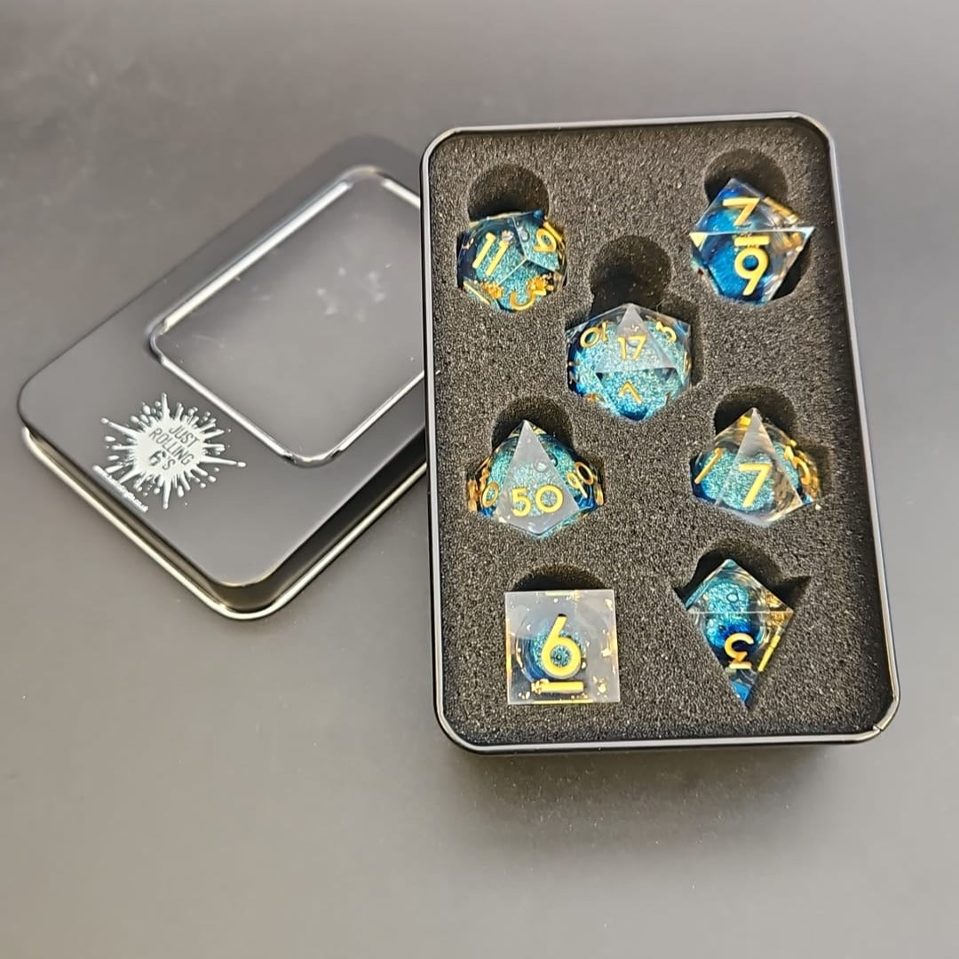 Clear & Blue Glitter 7 Piece Liquid Core Dice Set with Gold Numbering and highlights, in Metal Box